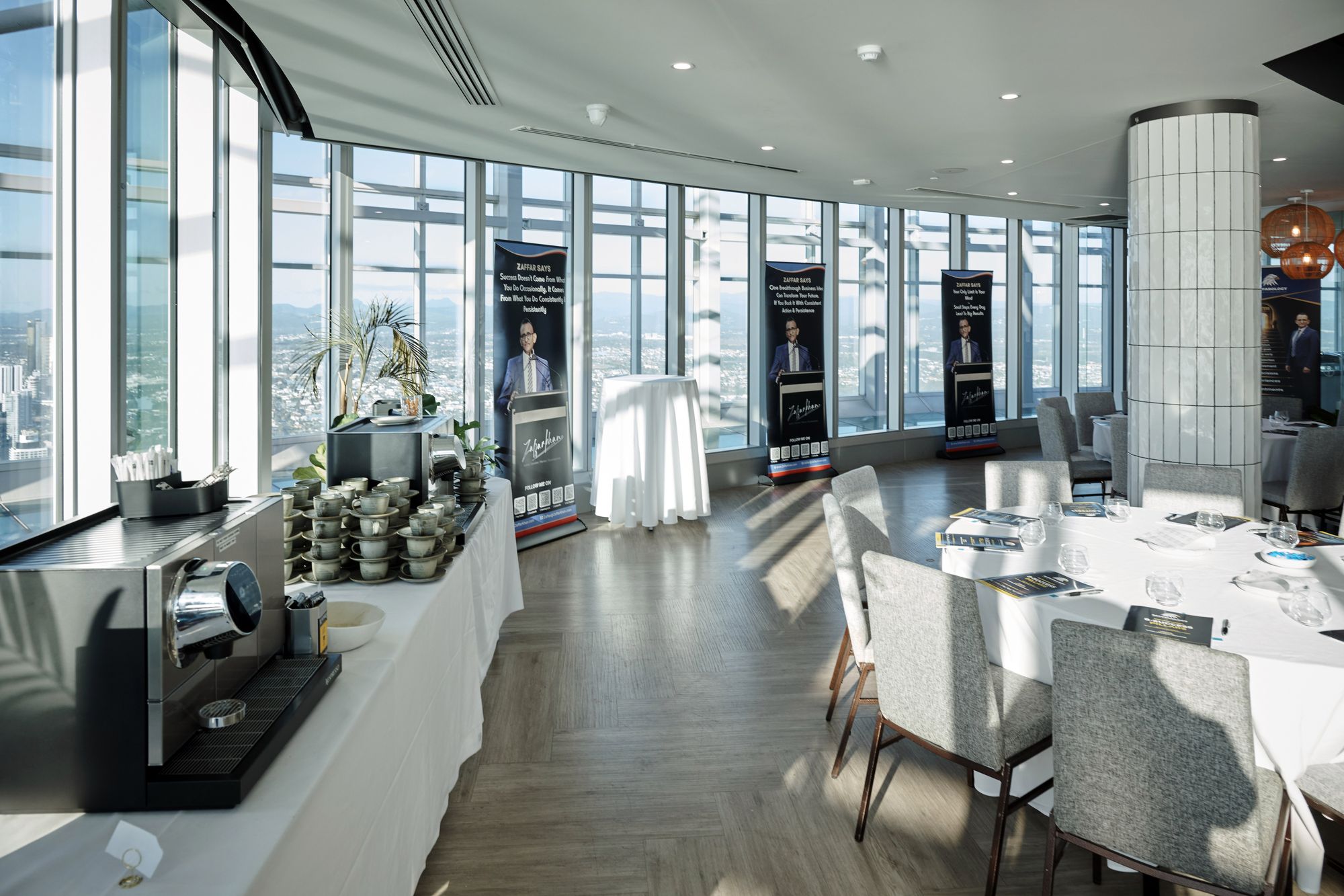 The workshop room set up before guests arrive, with a coffee station, banners and the Gold Coast skyline through floor to ceiling windows
