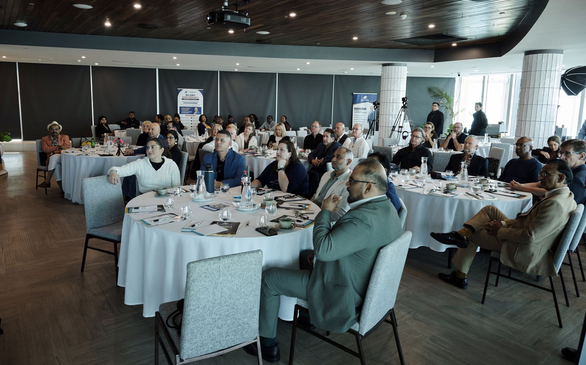 Wide view of the room with every round table occupied by business owners