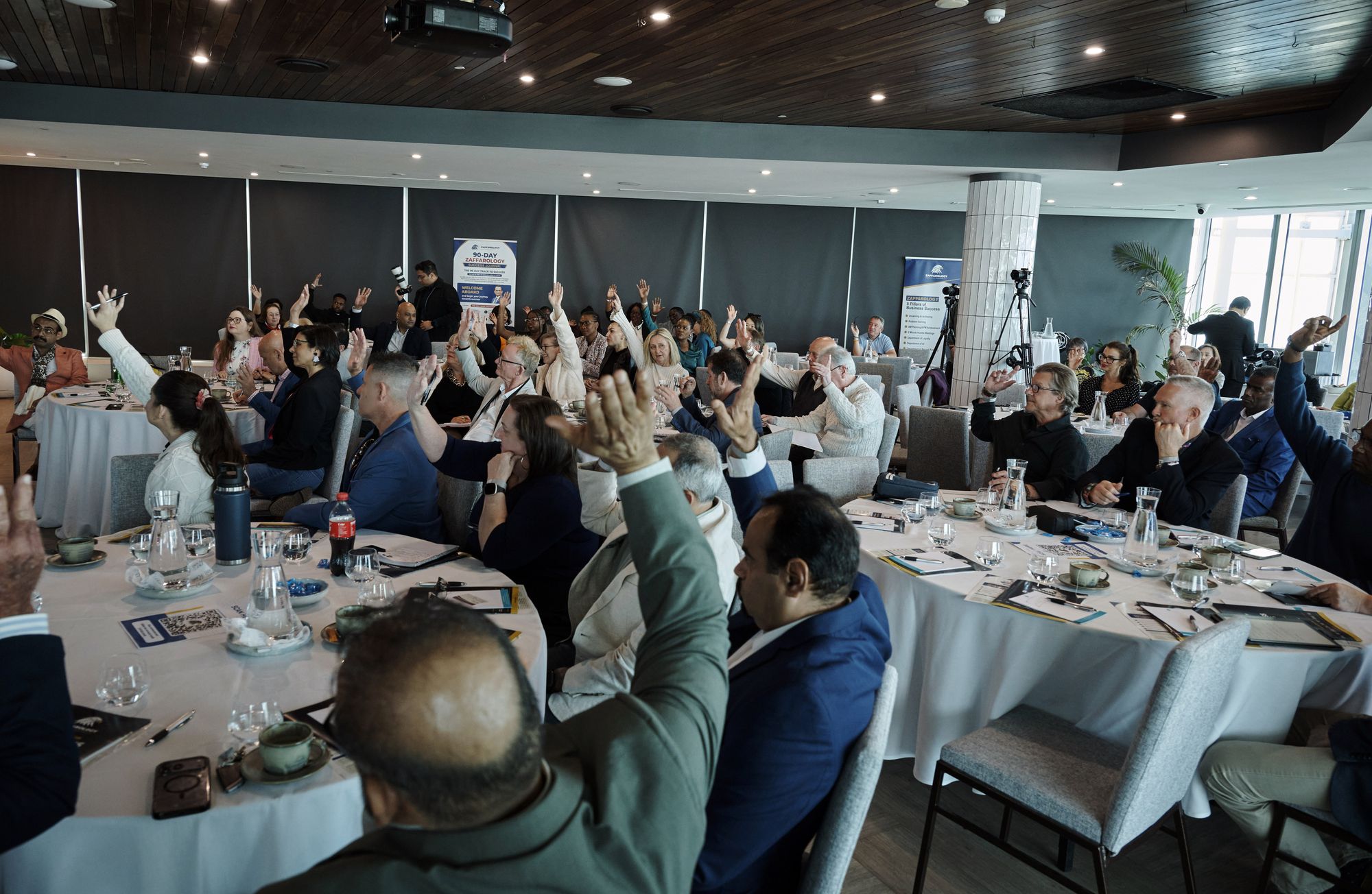 Many hands raised across the room during an audience exercise