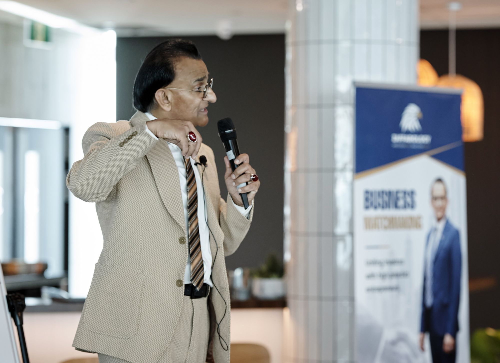 Zaffar Khan speaking beside the Business Matchmaking banner, uniting investors with entrepreneurs