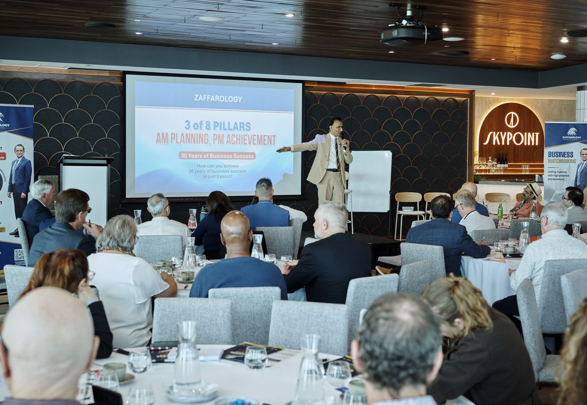 Zaffar Khan presenting the slide 3 of 8 Pillars, AM Planning PM Achievement, with the SkyPoint sign behind him