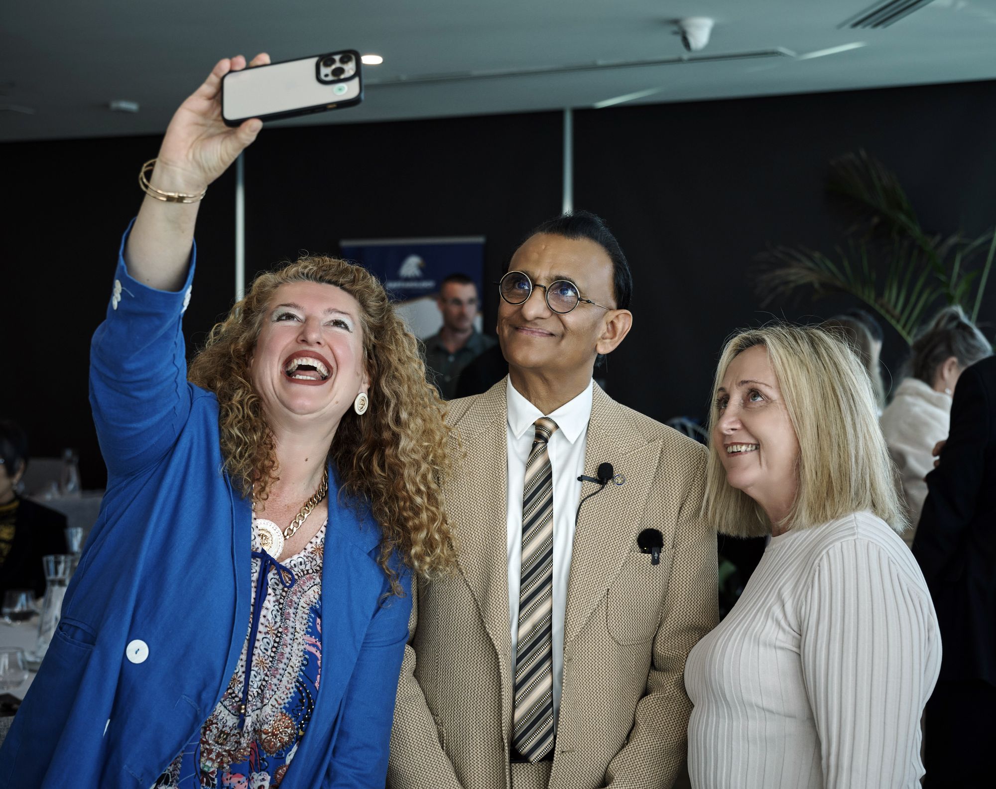 Two attendees laughing as they take a selfie with Zaffar Khan