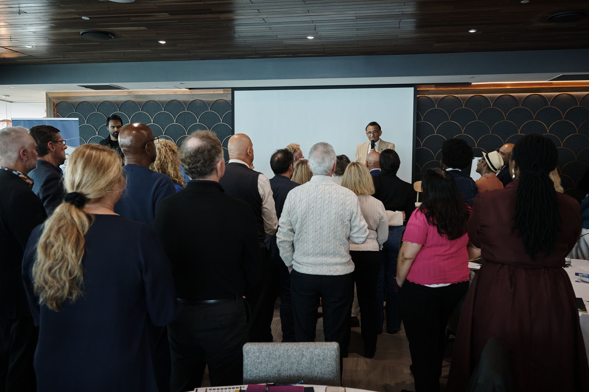 Attendees standing together facing the front during a group exercise
